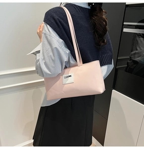 Nahaufnahme der rosa glänzenden Lackleder-Achseltasche mit weißem Etikett-Detail