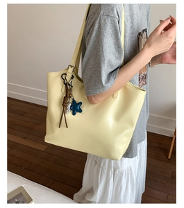 Détail du sac cabas jaune citron avec un charm étoile de mer bleue et une bandoulière
