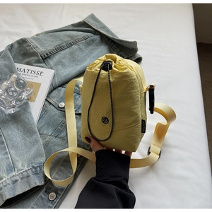 Détail d'un sac bandoulière jaune en nylon pour bouteille d'eau avec cordon de serrage
