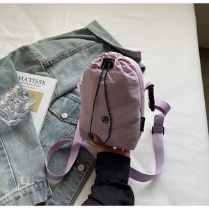 Vue détaillée du sac bandoulière en nylon violet avec sangle réglable et étiquette latérale
