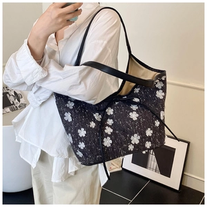 Close-up of retro pleated tote bag with 3D floral accents and elegant bow detail