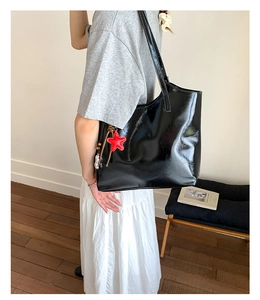 Sac fourre-tout noir brillant avec pendentif étoile rouge et longue bandoulière