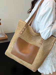 Commuter straw woven tote bag with brown leather patch and shoulder straps for beach vacation