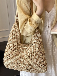 Handcrafted woven straw tote bag with brown leather shoulder straps for beach travel