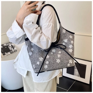 Detail of grey tweed tote bag featuring 3D white floral appliques and a bow detail