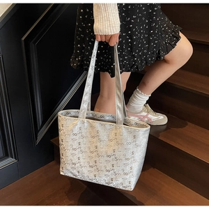 Detail of silver tote bag featuring numeric print and metallic synthetic leather finish