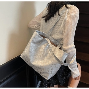 Detail view of large silver tote bag with digital prints on shoulder strap and body