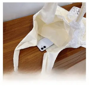 Internal view of white lace tote bag with side pocket showing phone storage capacity