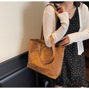 Detail view of large tote bag with metallic brown texture and black numeric print pattern