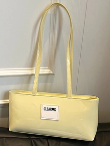Minimalistische cremegelbe Lackleder-Unterarmtasche mit CLEAR♥K-Label und schmalen Trägern