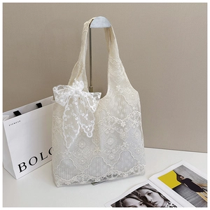 Detail of elegant cream floral lace tote bag with a large side bow decoration