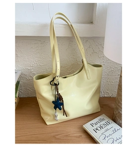 Détail du sac cabas crème avec breloque étoile bleue et longues anses dans un décor épuré