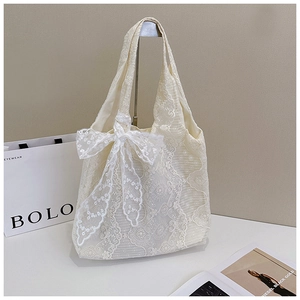 Detailed macro view of the cream lace tote bag featuring an elegant oversized bow design