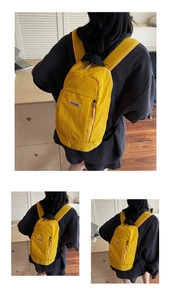 Detail shot of bright yellow nylon casual backpack with vertical zip and leather logo