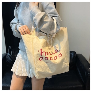 Détail de la doublure fleurie rouge et fermeture à ruban du sac cabas en toile beige
