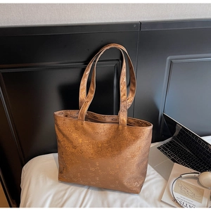 Detail of metallic bronze tote bag featuring all-over numeric print and long shoulder straps