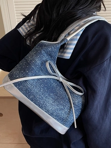 Borsa sottobraccio in denim blu scuro con fiocco argento e bordi in pelle metallizzata