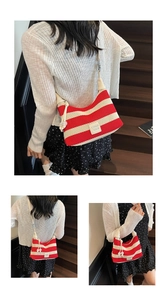 Detail of red and white striped crochet hobo bag with leather logo tag and bead tassel