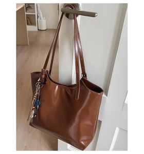 Vue détaillée du sac cabas en cuir marron avec fines bandoulières et breloque en étoile