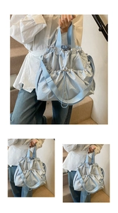 Detail of light blue drawstring canvas tote bag with pleated texture and adjustable strap