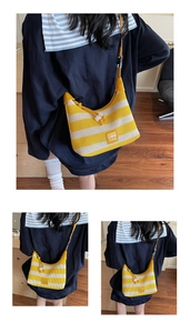 Detail of yellow striped mesh tote bag featuring premium leather logo and drawstring