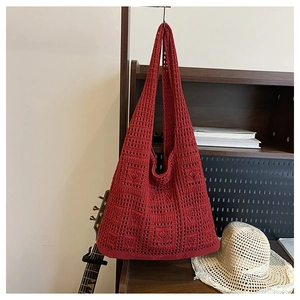 Detail of brick red crochet tote bag with hollow out mesh pattern and woven texture