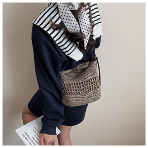 Macro detail of hand-woven straw bag with hollow mesh design and retro horn button