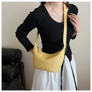 Détail d'un sac bandoulière croissant jaune en cuir à motif litchi avec bandoulière