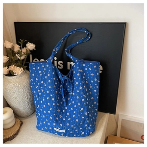 Détail du sac cabas matelassé à fleurs bleues avec étiquette tissée Magic Pocket