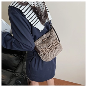 Detail of hand-woven mesh texture with leather trim and classic wooden toggle closure