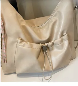 Detail of the durable drawstring pocket and soft beige leather texture on the tote bag