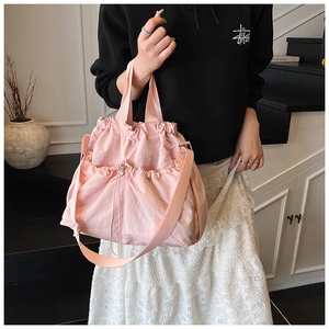 Detailed shot of the pink canvas tote bag with drawstring pockets and adjustable shoulder strap