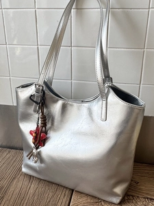 Grand sac cabas argenté métallique pour femme avec des breloques et un style minimaliste