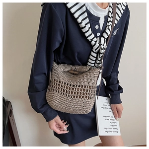 Close-up of handmade woven straw tote featuring bamboo buckle and leather strap