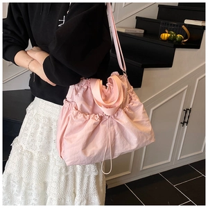 Detail of pink large-capacity drawstring tote bag with pleated design and side pocket