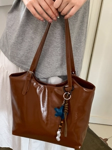 Sac cabas minimaliste en cuir brillant marron avec pendentifs étoile bleue et cacahuète