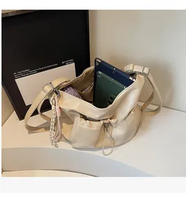 Detail view of beige large capacity tote bag with adjustable strap and drawstring pockets