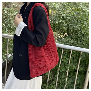 Detailed close-up of red crochet tote bag featuring intricate hollow-out geometric patterns