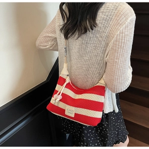 Detail of red and white striped knit hobo bag with beige leather logo and texture