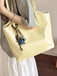 Sac cabas minimaliste jaune clair brillant avec charms porté à l'épaule