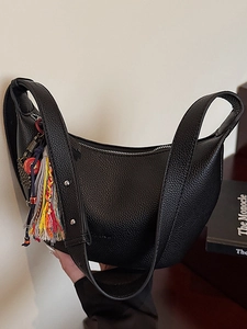 Sac croissant noir en cuir grainé avec un pendentif pompon coloré et dynamique