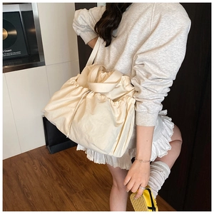Detail of soft cream canvas tote bag with drawstring closure and wide shoulder strap