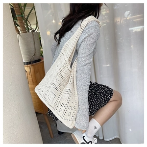 Close-up of cream knit hollow tote bag with intricate crochet geometric patterns for summer