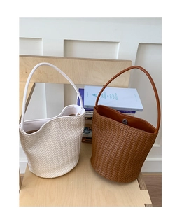 Detail of woven texture bucket bag in cream and brown with magnetic closure