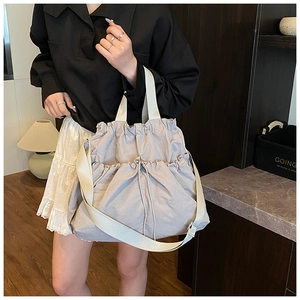 Detail of grey pleated drawstring canvas tote with durable strap and high-density texture