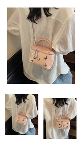 Detail of pink glossy box bag featuring silver metallic butterflies and chain strap