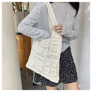 Detail of bohemian beige crochet tote bag showing hollow square patterns and soft knit texture