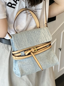 Chic blue denim crossbody bag with brown leather handles and gold buckle for women