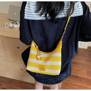 Detail of knitted yellow striped bag with CHIO'2ND label and beaded rope decoration