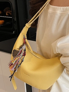 Sac à bandoulière jaune en forme de croissant avec motif litchi et pompon coloré